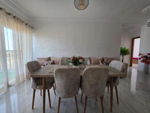 a dining room with a wooden table and chairs at Appartement sur Mer in El Arba de Trougout