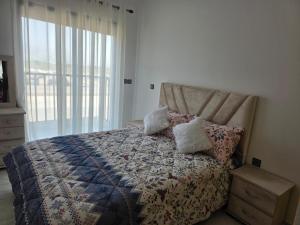 a bedroom with a bed with a quilt and pillows at Appartement sur Mer in El Arba de Trougout