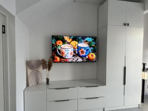 a living room with a tv on a wall at Wings Zen in Bosteri