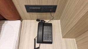 a phone sitting on top of a bed at The City Hotel in Kānpur