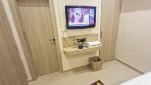 a hotel room with a television on a wall at The City Hotel in Kānpur