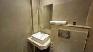 a bathroom with a sink and a mirror at The City Hotel in Kānpur +9 photos