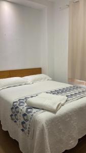 a bed with two white towels on top of it at Green duplex cottage in Camocim in Camocim