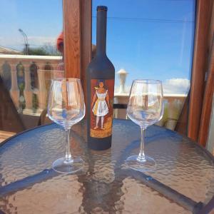 a bottle of wine and two wine glasses on a table at Guesthouse IMEDI in Velistsʼikhe