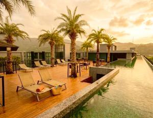 a resort with palm trees and a swimming pool at The Kamala View in Kamala Beach