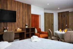 a hotel room with a table and a tv at Villa Bellevue Genève in Annemasse