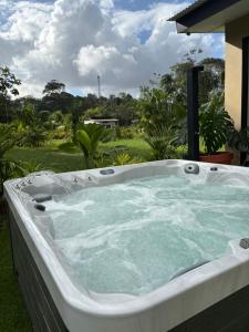 a jacuzzi tub sitting on top of a yard at Tycoon Luxury, SPA Privatif, Lit XXL, Cinema in Matoury