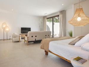 a bedroom with a large bed and a living room at Villa Calella Brava in Calella de Palafrugell