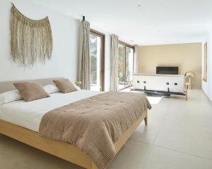 a white bedroom with a large bed and a fireplace at Villa Calella Brava in Calella de Palafrugell +47 photos