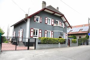 a gray house with red windows on a street at Villa Bellevue Genève in Annemasse