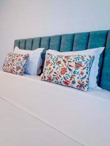 a bed with three pillows on it at DOCA Apartments 10 in Otopeni