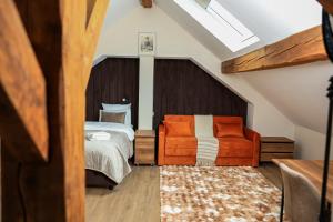 a bedroom with a bed and a orange chair at Villa Bellevue Genève in Annemasse