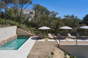 a swimming pool with lounge chairs and umbrellas at Villa Calella Brava in Calella de Palafrugell