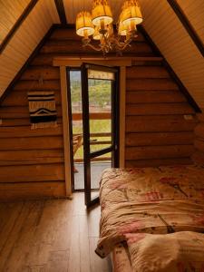 a bedroom in a log cabin with a bed and a chandelier at Lavender House in Slavske