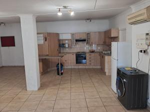 a kitchen with wooden cabinets and a white refrigerator at Charles Guest House in Germiston