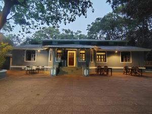 a house with tables and chairs in front of it at Shalimar in the Forest in Matheran