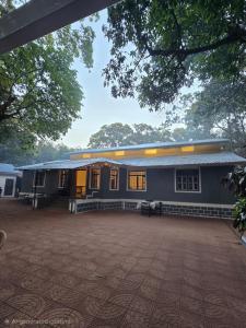 a blue building with a courtyard in front of it at Shalimar in the Forest in Matheran