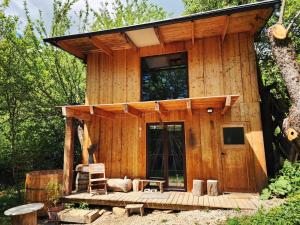 a small wooden cabin with a porch in the woods at Vceli RAJ Bojnice in Bojnice