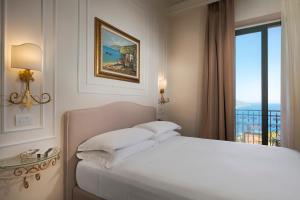 a white bedroom with a bed and a window at Hotel "La Pensione Svizzera" in Taormina +93 photos