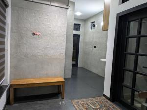 ein Flur mit einer Bank und einer Wand in der Unterkunft Abhimaan in Mysore