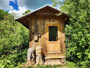 a small wooden out house with a door and some trees at Vceli RAJ Bojnice in Bojnice +12 photos