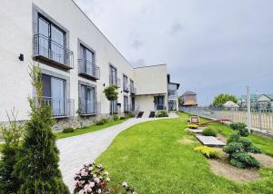 a building with a grass yard next to a building at Wings Zen in Bosteri