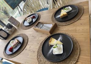 four plates of food on a wooden table at Wings Zen in Bosteri
