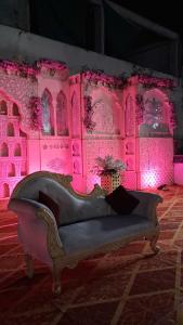 a couch in a room with pink lights at The JANAKPURI in Ajmer