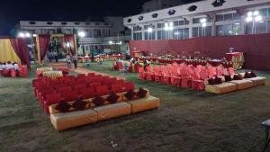 a group of red chairs in a field with people at The JANAKPURI in Ajmer