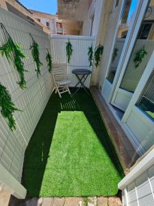 a small yard with green grass on a house at Studio 1 piece vacances proche de la mer in Le Grau-du-Roi