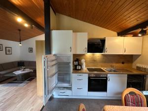 a kitchen with white cabinets and an open refrigerator at Ferienhaus Abendgold in Waldbrunn