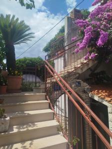 a set of stairs with purple flowers at ROOMS LUCE 2 & Supetar in Supetar