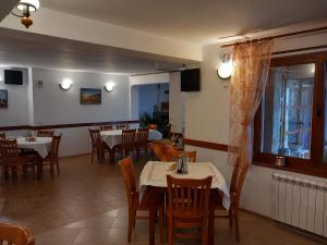 ein Restaurant mit Tischen und Stühlen und einem Fenster in der Unterkunft Kris Guest House in Dewin