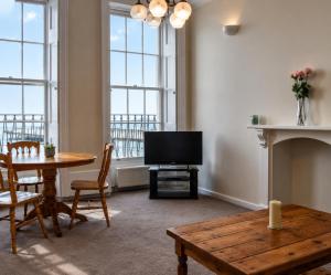 a living room with a television and a table and chairs at Coastal charm in Herne Bay