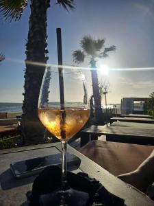a glass of wine sitting on a table near the ocean at Corte Atenea Guest House Experience & Spa in Agrigento