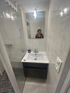 a woman taking a picture in a bathroom mirror at Location saisonnière in Sospel