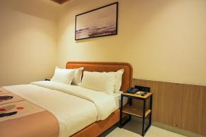 a hotel room with a bed and a table at Hotel Walnut - Near Jaipur Airport in Jaipur +23 photos