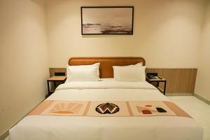 a bedroom with a bed with a picture on it at Hotel Walnut - Near Jaipur Airport in Jaipur