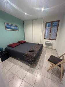 a bedroom with a bed and a chair in it at Location saisonnière in Sospel