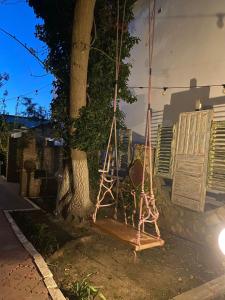 a swing hanging from a tree in front of a house at Vama Stone House in Vama Veche