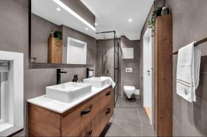 a bathroom with two sinks and a toilet at Sunny Garden Stay in Sandvika