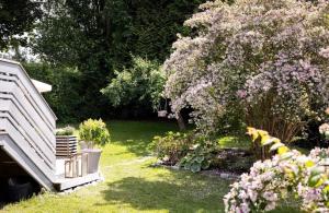 a garden with a tree and flowers in a yard at Sunny Garden Stay in Sandvika