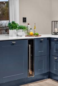 a kitchen with blue cabinets and a counter top at Sunny Garden Stay in Sandvika