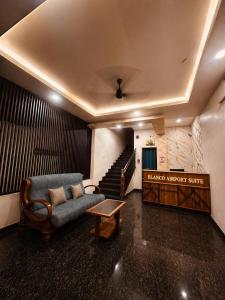a living room with a couch and a staircase at Blanco Airport Suite in Kāladi