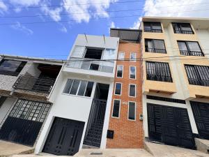 an apartment building with black doors on a street at Villa Celeste Guaduas El Mirador in Guaduas