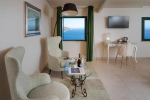a living room with chairs and a table and a window at Hotel "La Pensione Svizzera" in Taormina