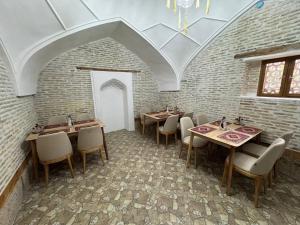 a dining room with tables and chairs and a ceiling at Turkman Madrasah XIX Century Hotel in Bukhara