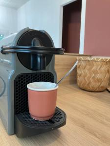 a coffee maker with a cup on a table at Studio Cosy près de la forêt in Saint-Prix