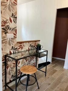 a black desk with a chair next to a wall at Studio Cosy près de la forêt in Saint-Prix