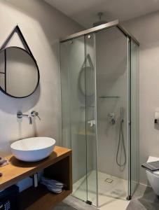a bathroom with a glass shower and a sink at Seaside Tinos in Kionia +101 photos